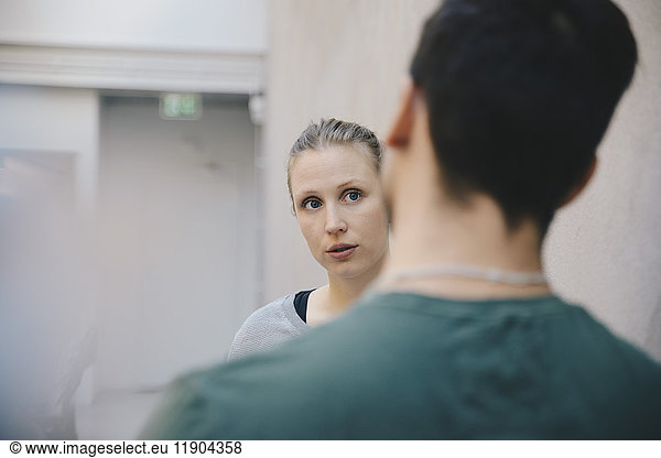 Female computer programmer discussing with male colleague in office