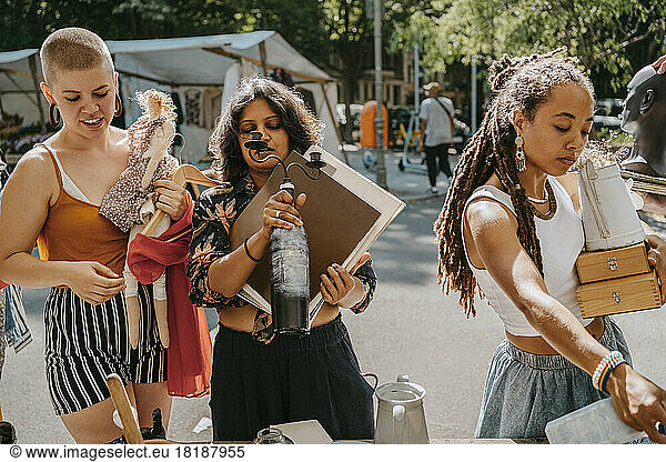 Female customers choosing products while shopping together at flea market