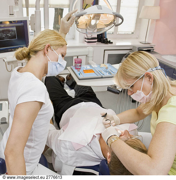 Female dentist working on a male patient