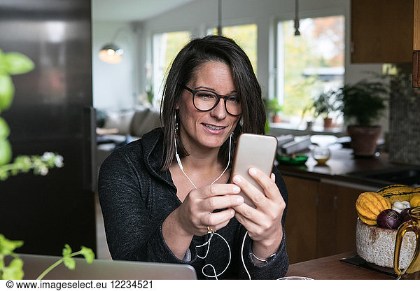 Female design professional using mobile phone while sitting in home office