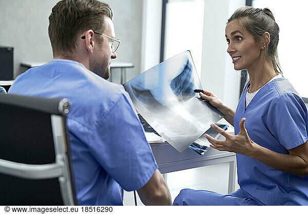 Female doctor discussing over medical x-ray with colleague