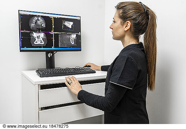 Female doctor examining x-ray image on computer at clinic