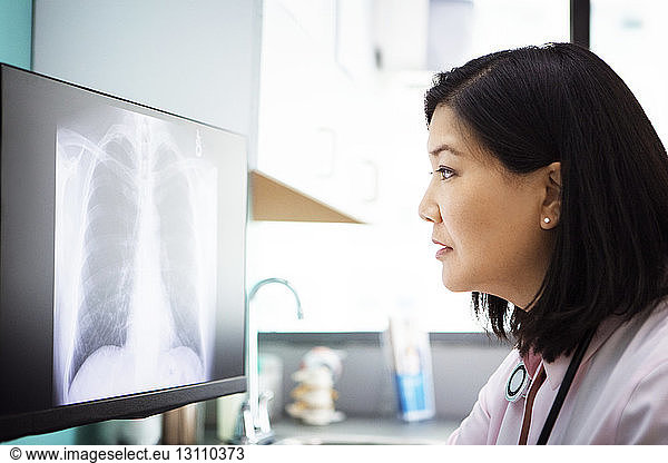 Female doctor examining x-ray on computer in clinic