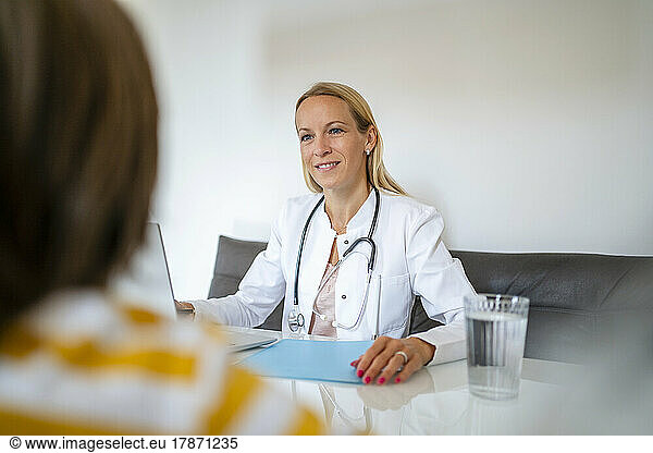 Female doctor smiling at boy in medical practice