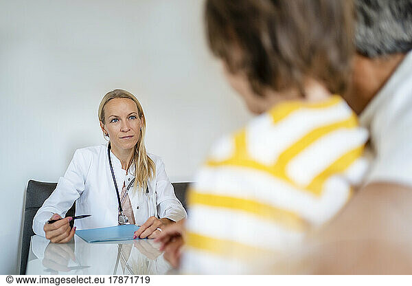 Female doctor with father and son in medical practice