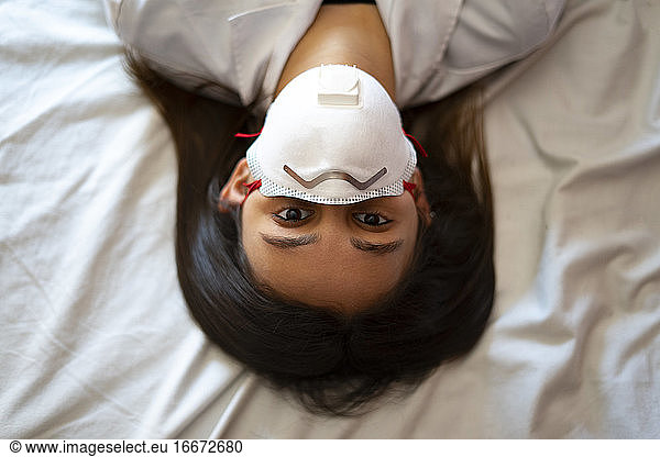 Female doctor with medical mask on a white background.
