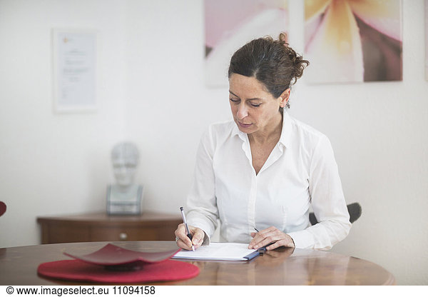 Female doctor writing prescription in hospital