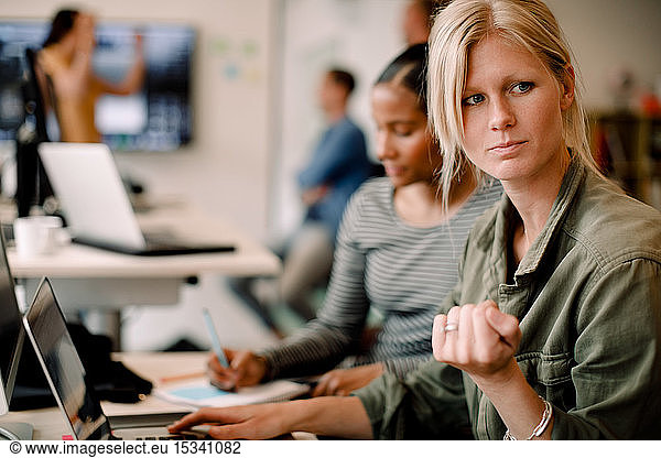 Female entrepreneur looking away while using laptop at office desk