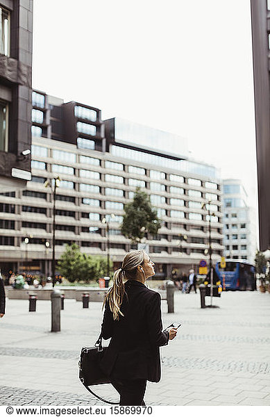 Female entrepreneur looking up while walking outdoors