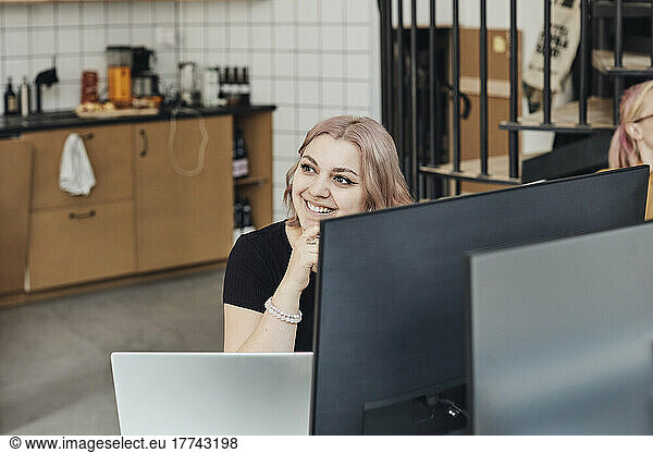 Female entrepreneur smiling during meeting in tech start-up office