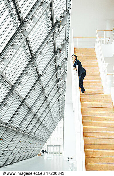 Female entrepreneur standing on steps in corridor