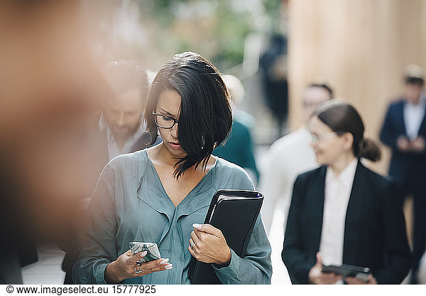 Female entrepreneur using smart phone outside office