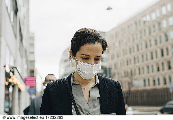 Female entrepreneur with protective face mask in city