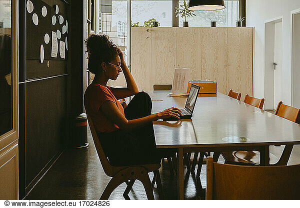 Female entrepreneur working on laptop in office