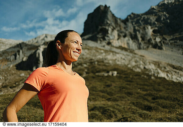 Female explorer smiling while standing against mountain at Cares Trail in Picos De Europe National Park  Asturias  Spain