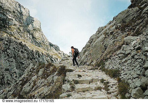 Female explorer with backpack walking on mountain of Cares Trail  Picos De Europe National Park at Asturias  Spain
