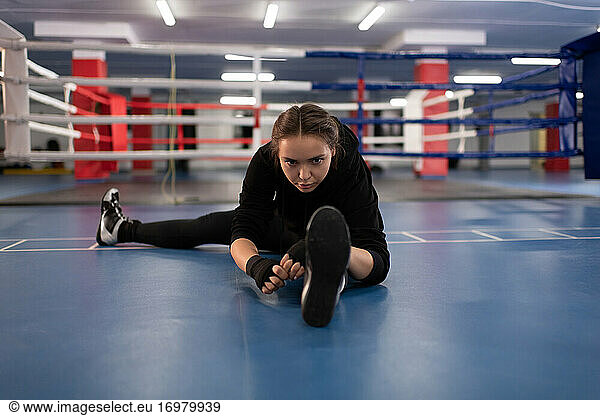 Female fighter stretching during workout
