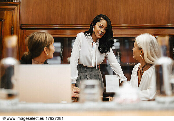 Female financial advisors discussing with colleagues in meeting at workplace