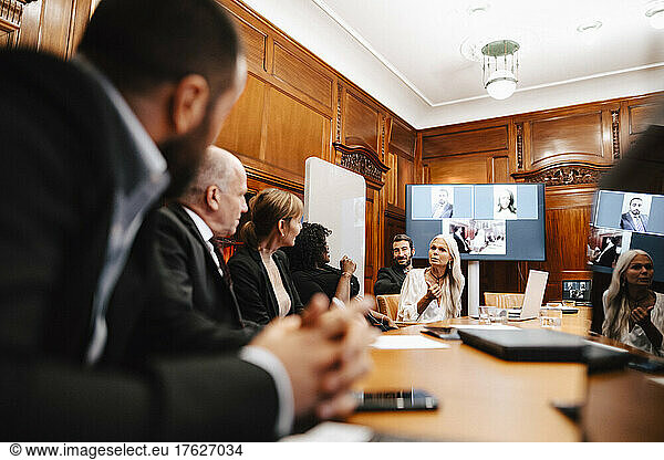 Female financial expert discussing with colleagues in conference at office