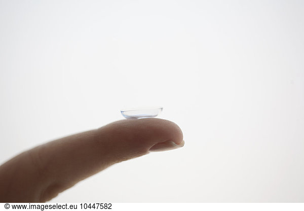 female finger with contact lens