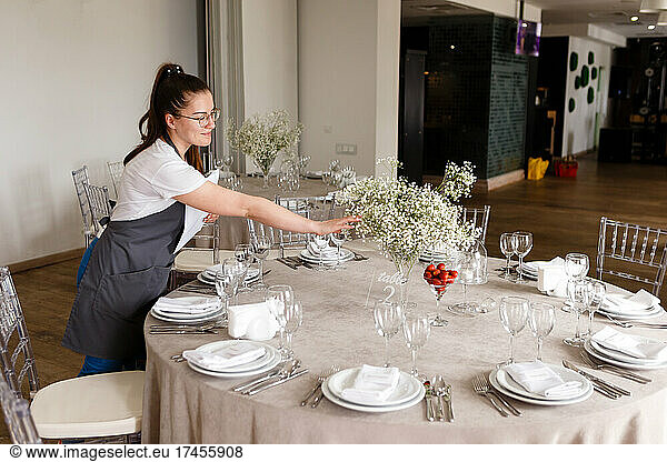 female florist decorator decorates the wedding table