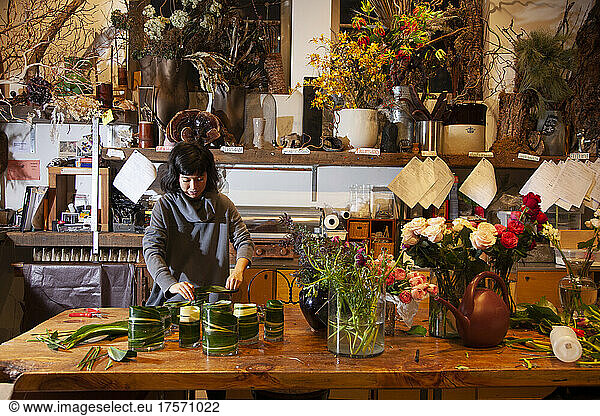 Female Florist Lining Vases with Leaves for Flower Bouquets  NYC