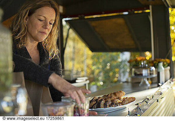 Female food cart owner arranging pastries