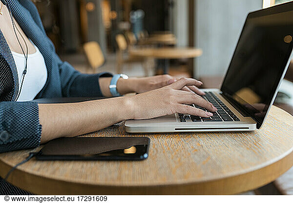 Female freelance worker using laptop in cafe