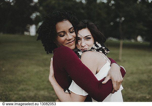 Female friends embracing at park