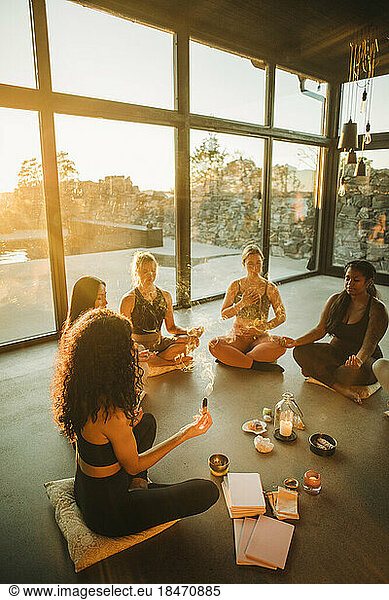Female friends meditating together while sitting at retreat center