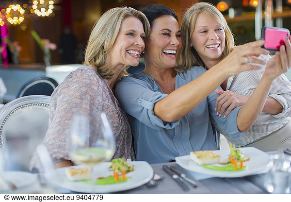 Female friends taking selfie in restaurant