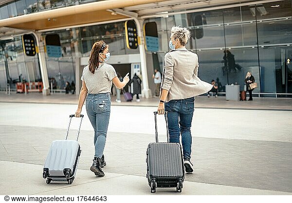 Female friends with luggage approaching the airport ready for the trip