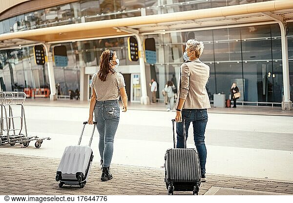 Female friends with luggage approaching the airport ready for the trip