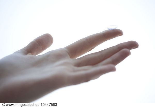 female hand with contact lens