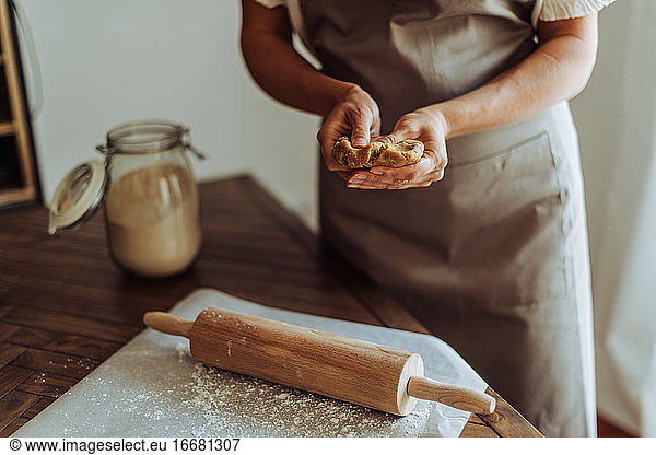 Female hands preparing dough for rolling