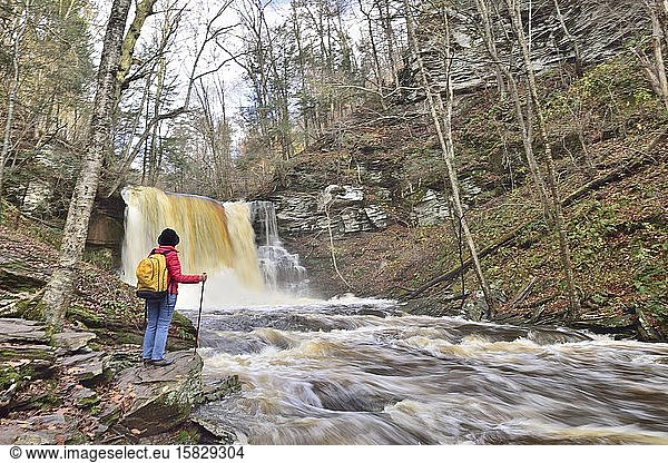 Female hiker admires beautiful waterfalls