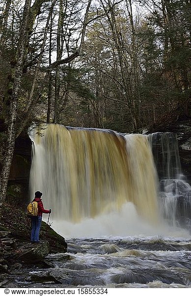Female hiker admires beautiful waterfalls