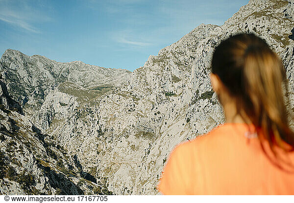 Female hiker admiring mountain view while standing at Cares Trail in Picos De Europe National Park  Asturias  Spain