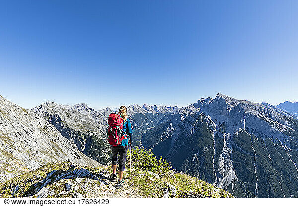 Female hiker admiring view of Mittenwalder Hohenweg in summer