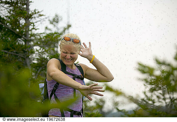 Female hiker being attacked by bugs on the Welch-Dickey trail.