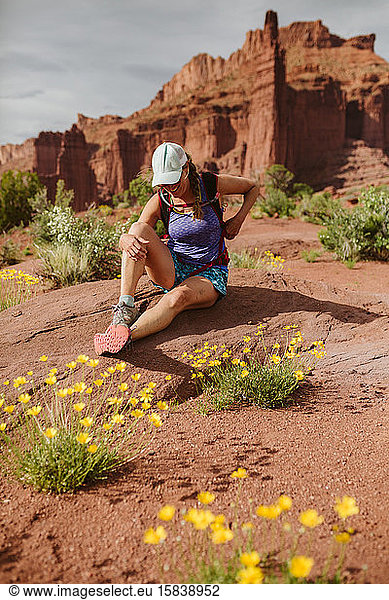 female hiker laughs as she sits for a water break in utah desert