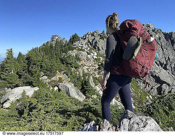 Female hiker looking back at Mount Pilchuck fire lookout tower