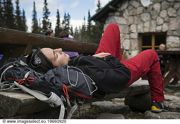 Female hiker sleeps on bench outside Murowaniec hut  Tatra mountains  Poland