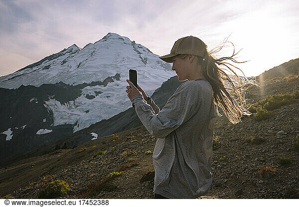 Female Hiker Taking Photo With Phone At Mount Baker