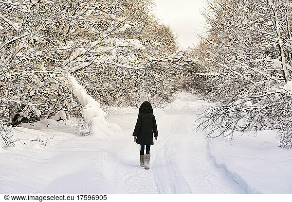 Female hiker walking in snow covered forest