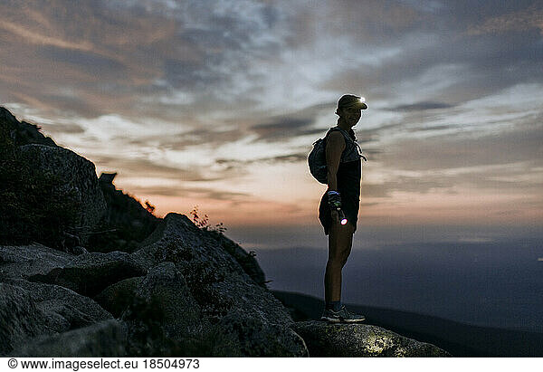 female hiker with headlamp hikes Katahdin at sunrise