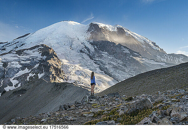 Female in blue shirt standing in front of Mount Rainier