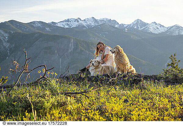 Female in dress posing with dogs with mountain views