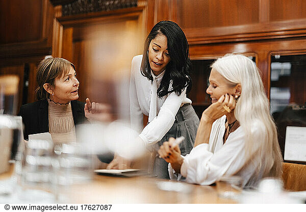 Female lawyer discussing with colleagues in meeting at office