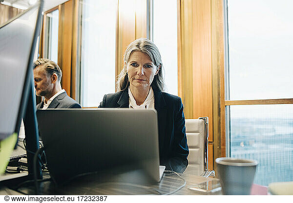 Female lawyer walking on laptop in office